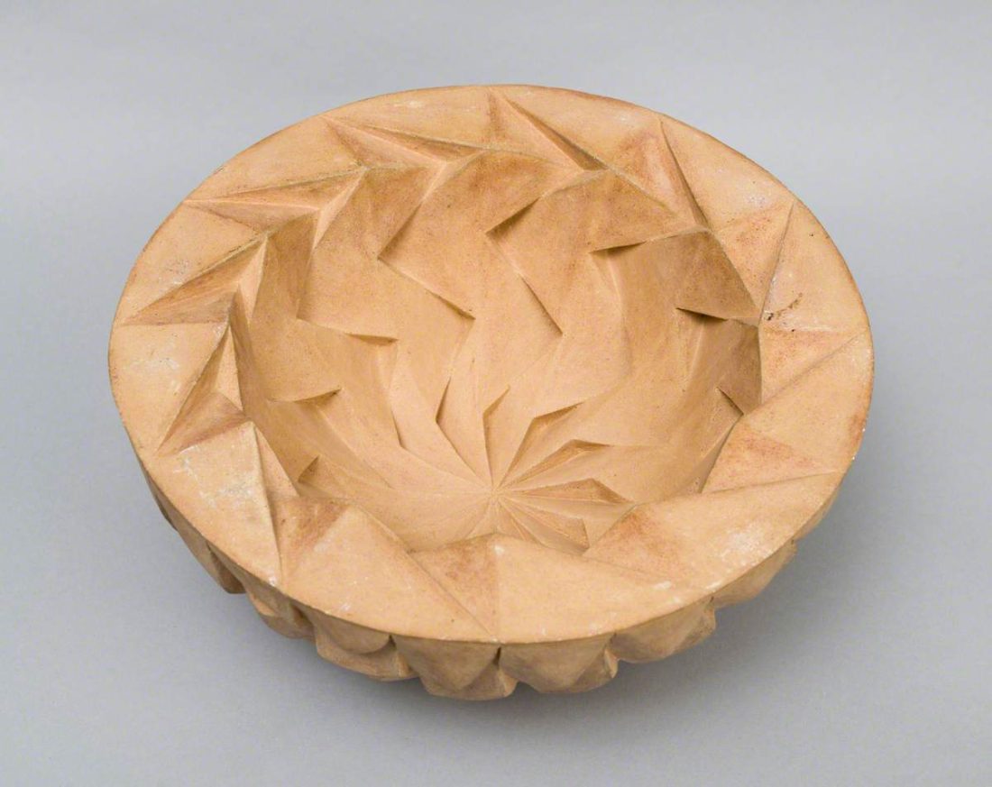 Carved ceramic sculpture shaped like a deep bowl made from a pale unglazed clay by artist Halima Cassell. The piece is titled Blackburn on the Hill.