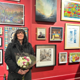 Second Place winner of Art Open Exhibition stood next to their work